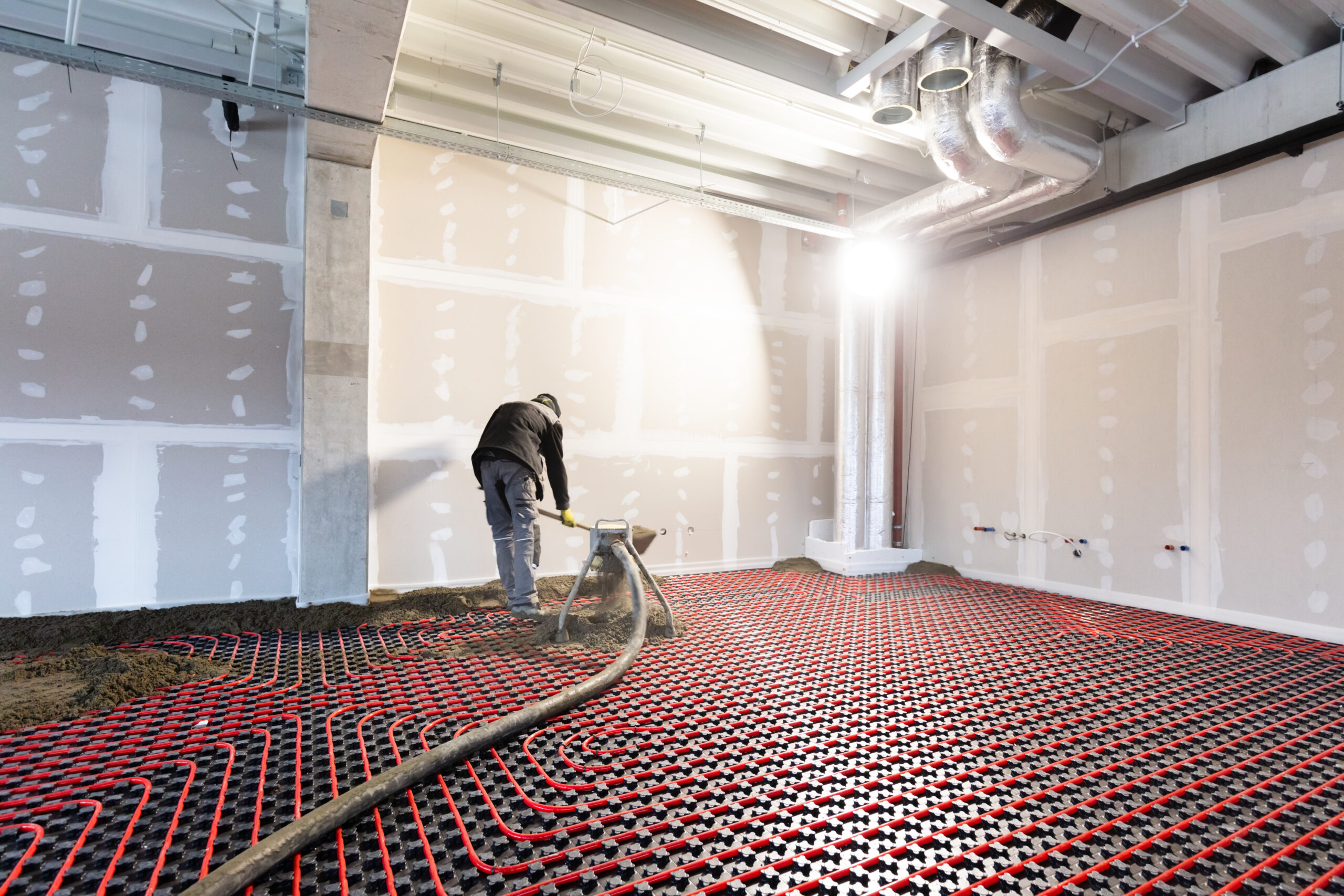 Worker installing floor heating in a new building. Interior design and finishing industry. Office and apartment